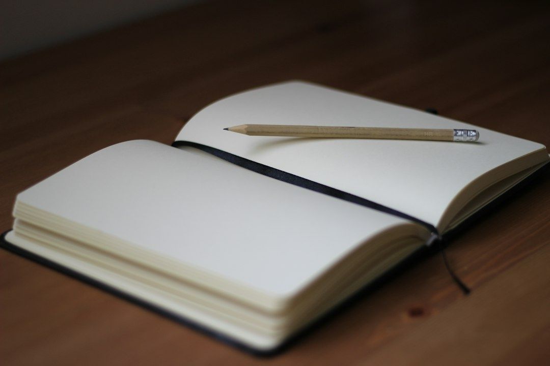 Open blank notebook with a wooden pencil on a table